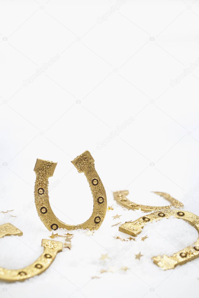 close-up shot of horseshoes on snow with confetti for christmas background
