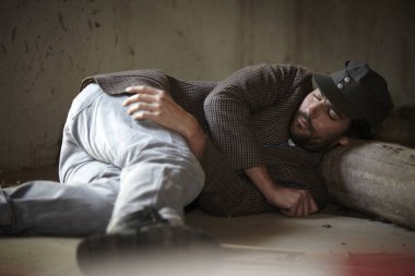 kirli elbiseli dilenci adam yerde yatan ve ihmal edilen binada uyku 