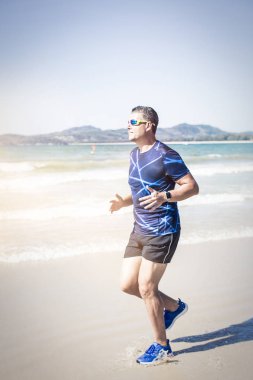 tropik sahilde güneşli gün koşan atletik adam 