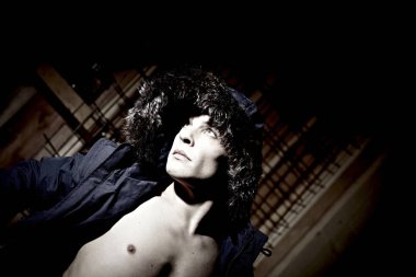 portrait of handsome male model in warm  jacket posing on dark studio background 