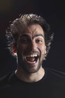 çılgın sakallı Brunet adam kamera bakıyor ve açık ağız ve büyük gözler, yakın çekim ile bağırarak portre