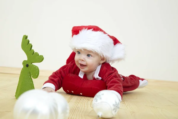 Милый Маленький Ребенок Красном Костюме Санта Клауса Играет Белыми Безделушками — стоковое фото