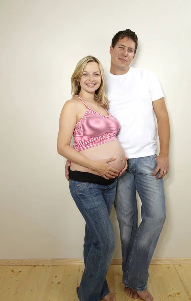 Homem Feliz Com Loira Grávida Esposa Posando Juntos Perto Parede — Fotografia de Stock