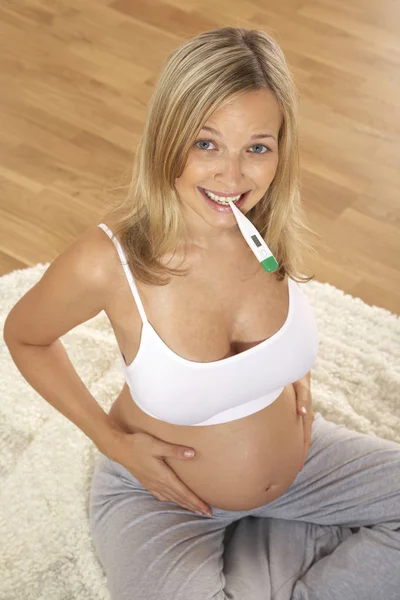 Счастливая Беременная Женщина Держащая Тест Беременность Рту Сидящая Полу Дома — стоковое фото