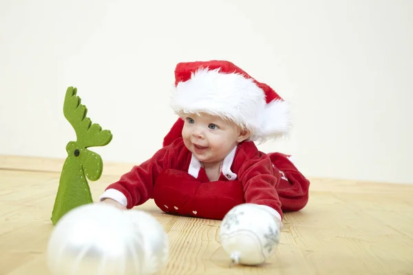 Милый Маленький Ребенок Красном Костюме Санта Клауса Играет Белыми Безделушками — стоковое фото
