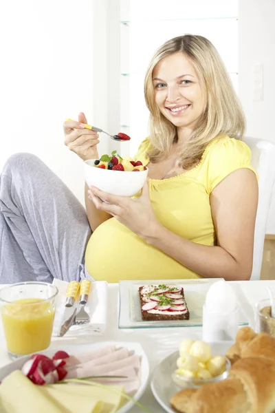 Feliz Mujer Embarazada Sentada Silla Comiendo Ensalada Frutas Del Tazón —  Fotos de Stock