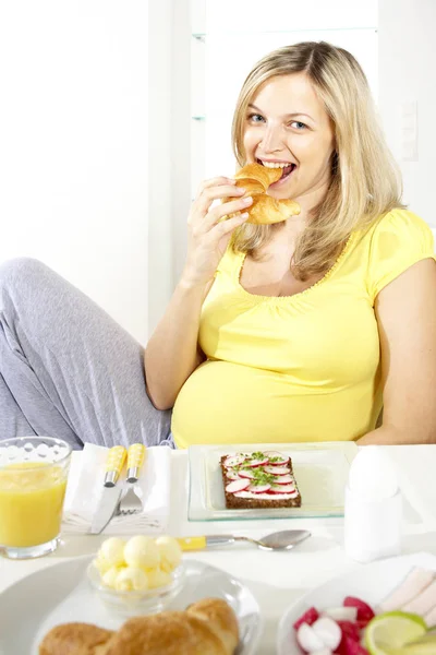 Gelukkig Zwangere Vrouw Croissant Zittend Een Stoel Buurt Van Tabel — Stockfoto