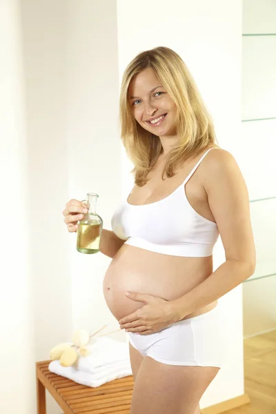 Rubia Embarazada Vistiendo Ropa Interior Blanca Masajeando Vientre Con Aceite — Foto de Stock