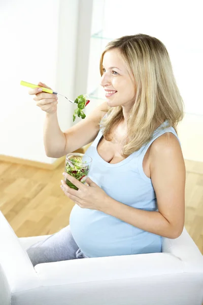 Gelukkig Zwangere Vrouw Zittend Een Fauteuil Salade Van Glas Thuis — Stockfoto