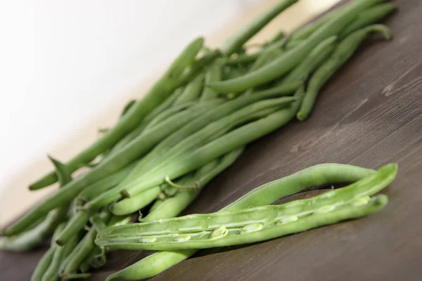 pile of green bean pods on wooden background