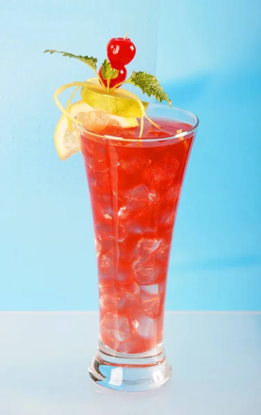 红色鸡尾酒柠檬和石灰片和樱桃装饰在玻璃充满冰块 — 图库照片