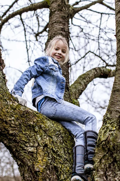 Маленькая Красивая Девочка Сидит Ветке Дерева Весеннем Парке — стоковое фото