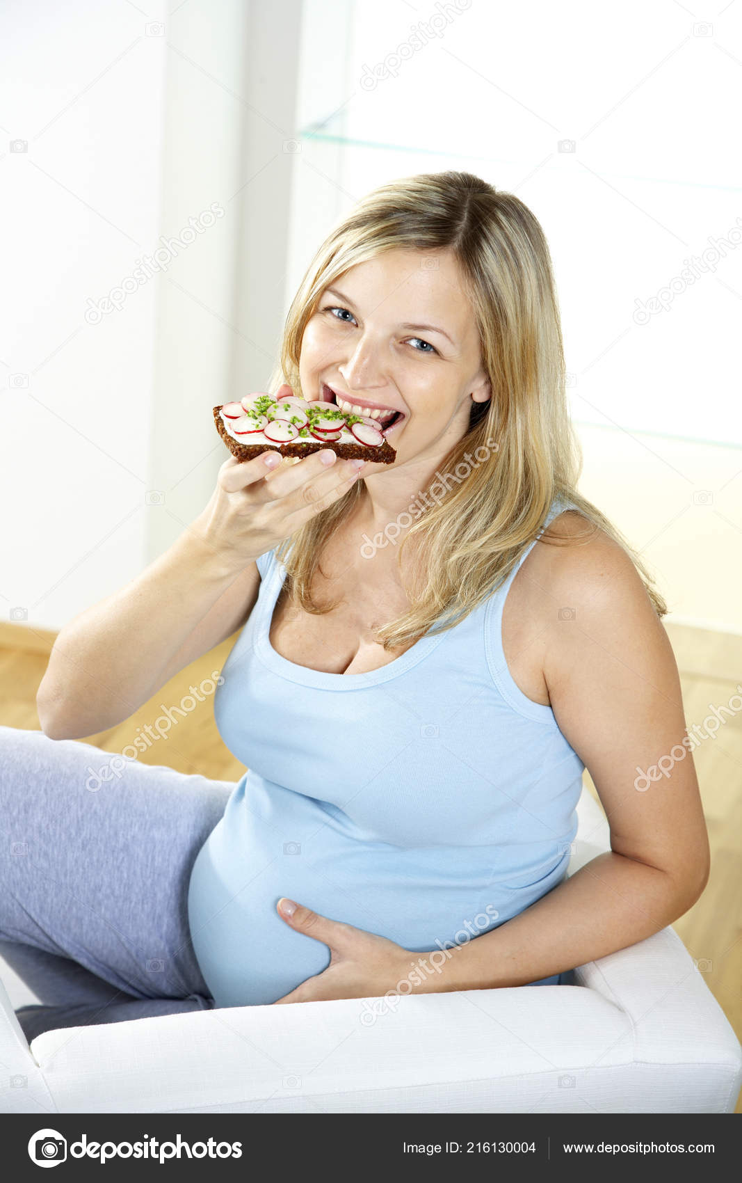 Happy Pregnant Woman Sitting Armchair Eating Radish Sandwich Home Stock