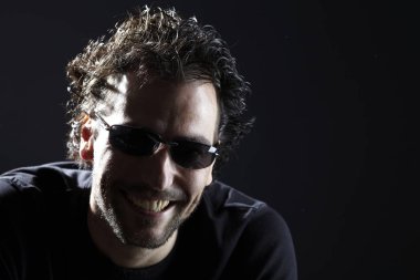 karanlık arka planda gülümseyen güneş gözlüğü komik adam portre 