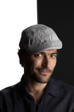 kapak ve gömlek gülümseyen ve siyah beyaz arka planda kamera bakarak mutlu tıraşsız yakışıklı adam portre 