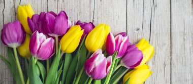 Ahşap arka plan, yakın çekim, tatil kavramı üzerinde pembe ve sarı laleler