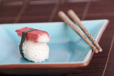 suşi Yengeç sopa ve mavi tabakta yemek çubukları ile yakın çekim    