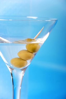 üzerinde mavi arka plan, zeytinli martini cam yakın çekim