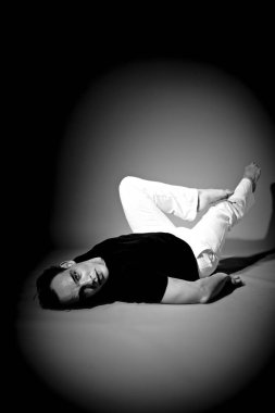 koyu stüdyo arka plan üzerinde yükseltilmiş bacaklar ile poz yakışıklı erkek model 