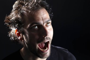 koyu arka planda açık ağız yapması ile sakallı Brunet adam portre, yakın çekim