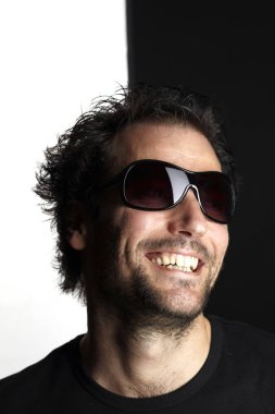 siyah ve beyaz arka planda gülümseyen güneş gözlüğü komik adam portre 