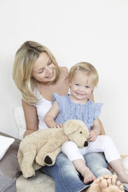 Anne ve çocuk oyuncak ayı ile evde oynarken eğleniyor 