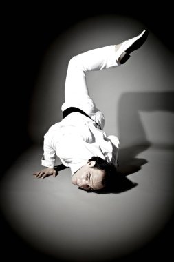 koyu stüdyo arka planda yerde yatarken yakışıklı erkek model dans 