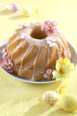 sarı arka plan üzerinde çiçek ile tatlı oster gugelhupf ile plaka 