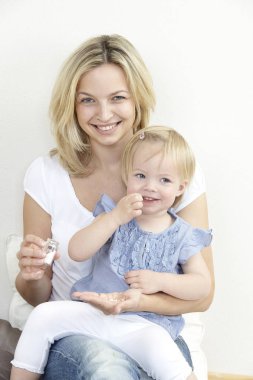 Anne ve çocuk evde globuli ilaçlar ile oynarken eğleniyor 