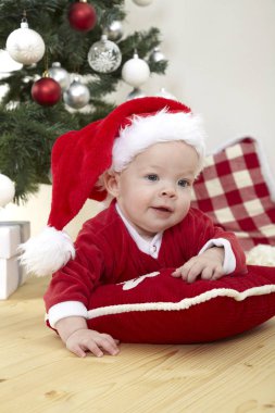 Şirin Bebek yastık dekoratif Noel ağacı yakınındaki yatan kırmızı Noel Baba kostüm  