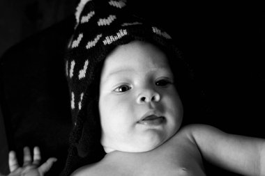 Siyah arka planda poz veren şapkalı şirin küçük bebek, yakın görüş.  