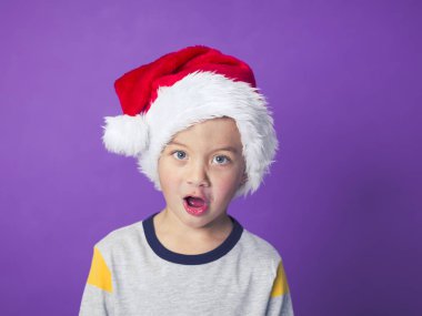 şok çocuk gözleri iri ve açık ağız Menekşe arka planda, Noel kavramı bağırarak ile kırmızı santa şapka  