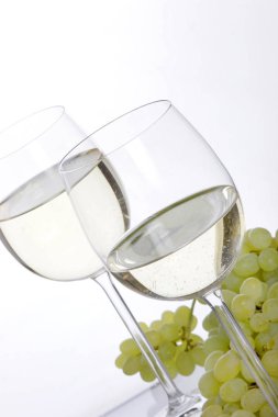 beyaz şarap ve üzüm beyaz zemin üzerine izole iki kadehlerin yakın çekim 