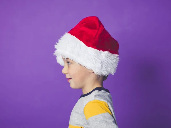 Side View Portrait Boy Wearing Red Santa Hat Posing Violet — Stock Photo, Image