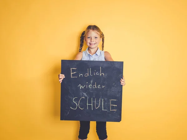 Cute Uczennica Warkoczykami Gospodarstwa Tablica Tekstem Końcu Szkoła Ponownie Języku — Zdjęcie stockowe