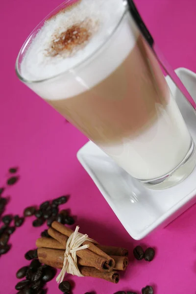 Glas Caffe Latte Med Kaffebönor Och Kanelstänger Ljusa Rosa Bakgrund — Stockfoto