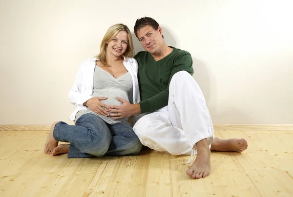 Marido Abraçando Barriga Esposa Grávida Enquanto Sentado Chão Madeira Casa — Fotografia de Stock