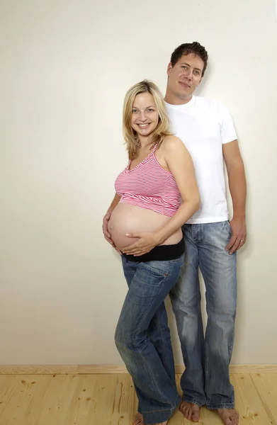 Hombre Feliz Con Esposa Embarazada Rubia Posando Juntos Cerca Pared —  Fotos de Stock