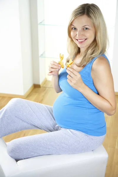 Gelukkig Zwangere Vrouw Met Zoete Gevlochten Gist Cookies Zittend Fauteuil — Stockfoto