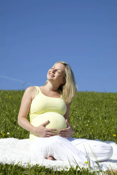 Happy Pregnant Woman Cupped Her Belly Both Hands While Sitting Stock Picture
