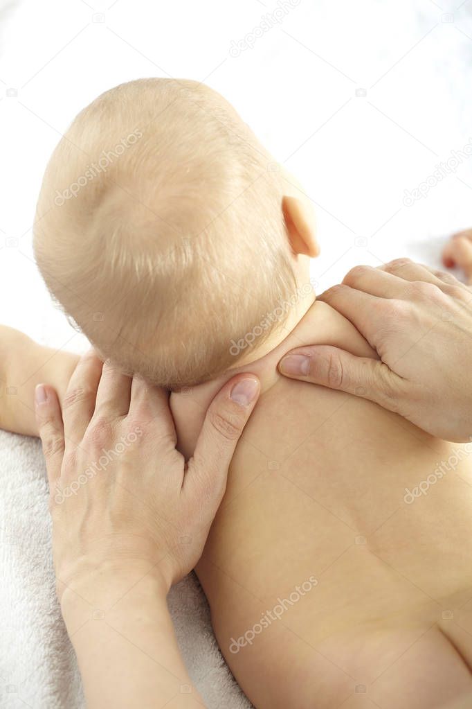 Young woman massaging seven month old baby 