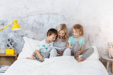 Güzel annem evde yatakta yatarken sırasında çocuklar için masal okuma 