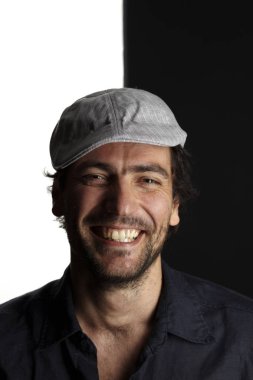 kapak ve gömlek gülümseyen ve siyah beyaz arka planda kamera bakarak mutlu tıraşsız yakışıklı adam portre 