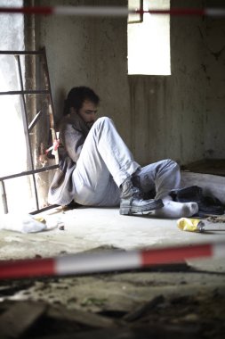 terk edilmiş binada uyuyan kirli giysiler içinde sarhoş evsiz adam 