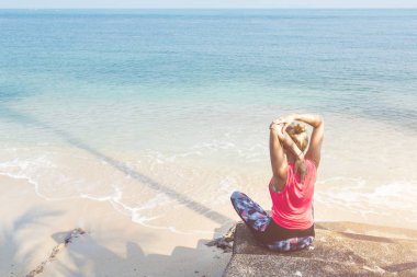 Kafkas kadın yaz güneşli kumlu plajda otururken germe 
