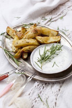 fırında patates dilimleri biberiye ve tepsisindeki sosu ile 