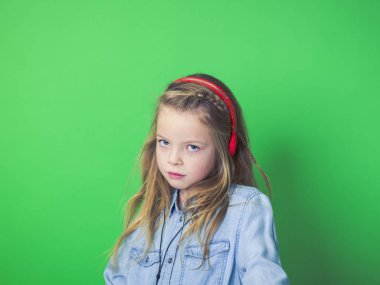 beautiful girl with red headphones in front of green background in the studio