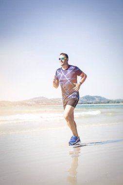 tropik sahilde güneşli gün koşan atletik adam 