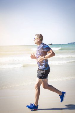 tropik sahilde güneşli gün koşan atletik adam 