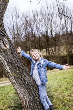 ağaç bahar Park üzerinde tırmanma küçük güzel kız 